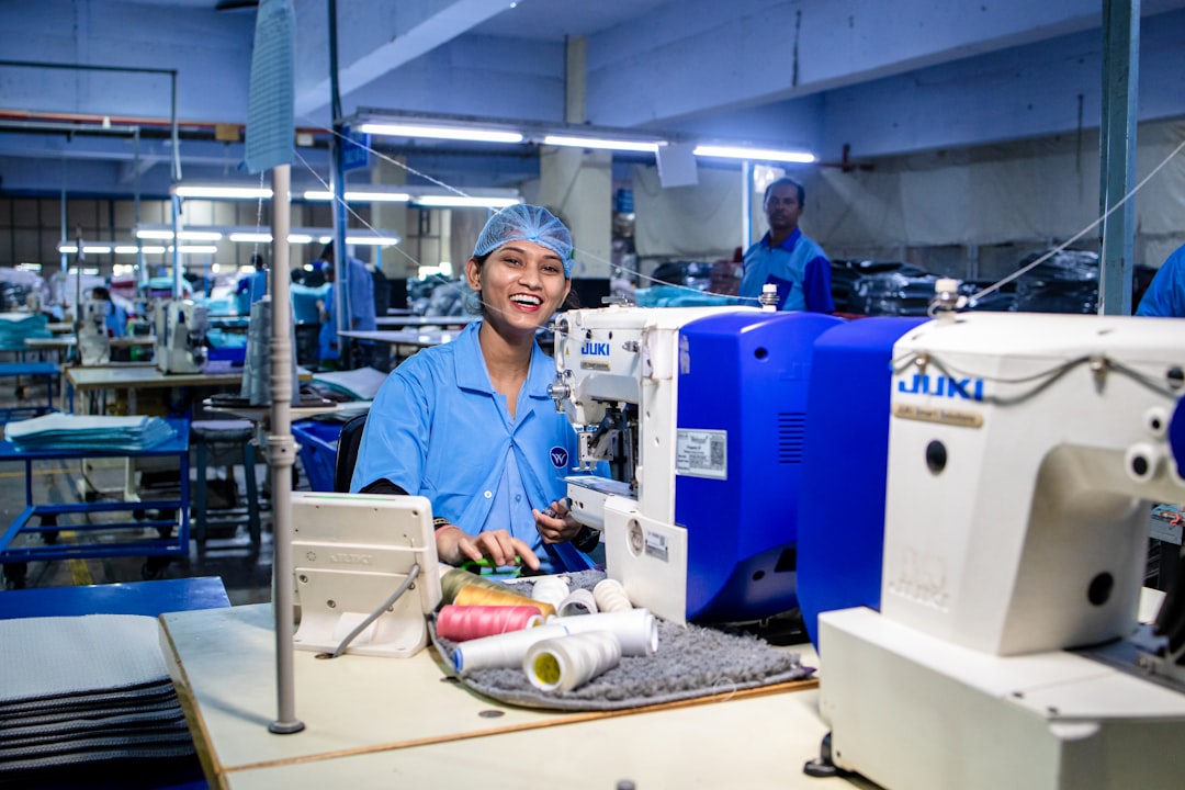 Photo by EqualStock A smiling woman works at a sewing machine.
